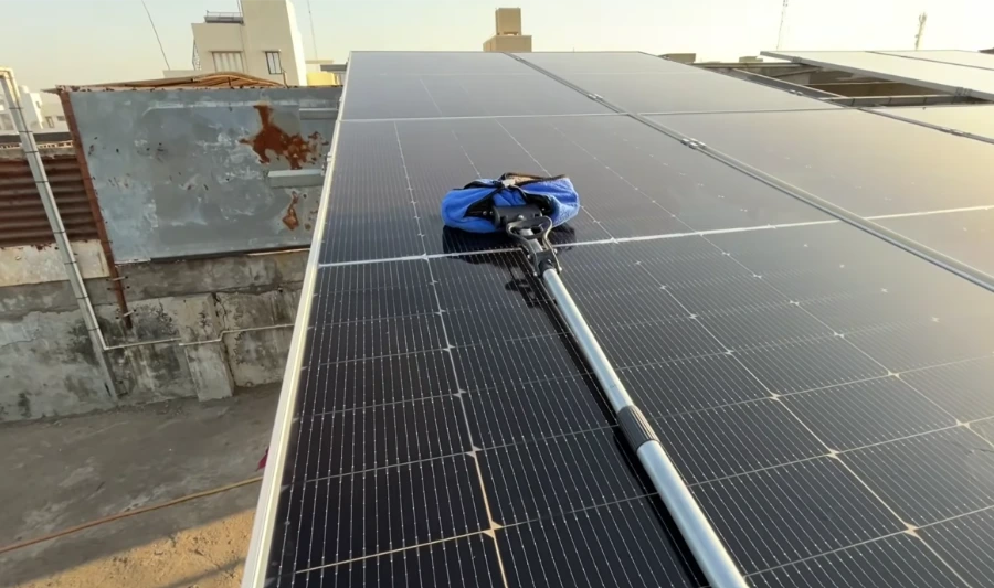 Microfiber mop on a pole cleaning a flat-roof solar array