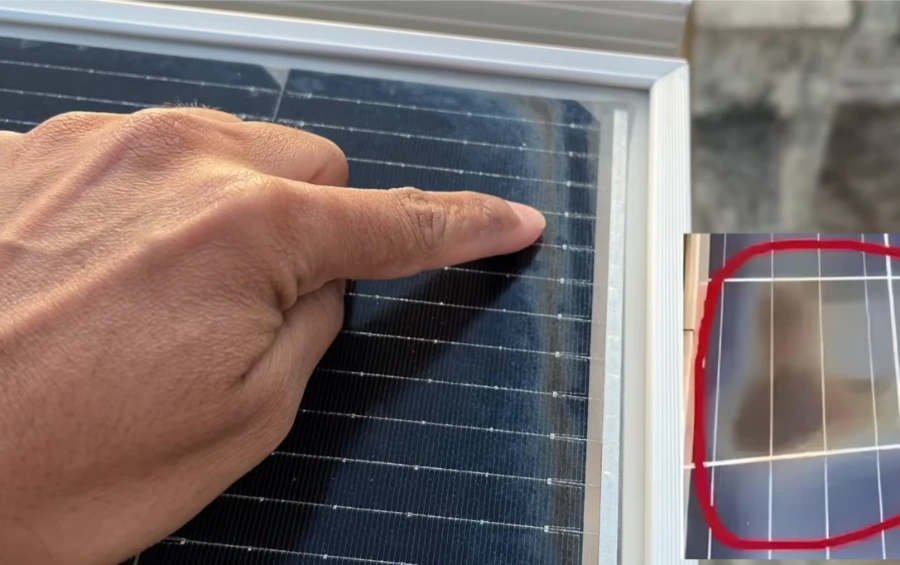 Finger pointing to a damaged, discolored edge of a solar panel during an inspection, solar panel inspection Las Vegas