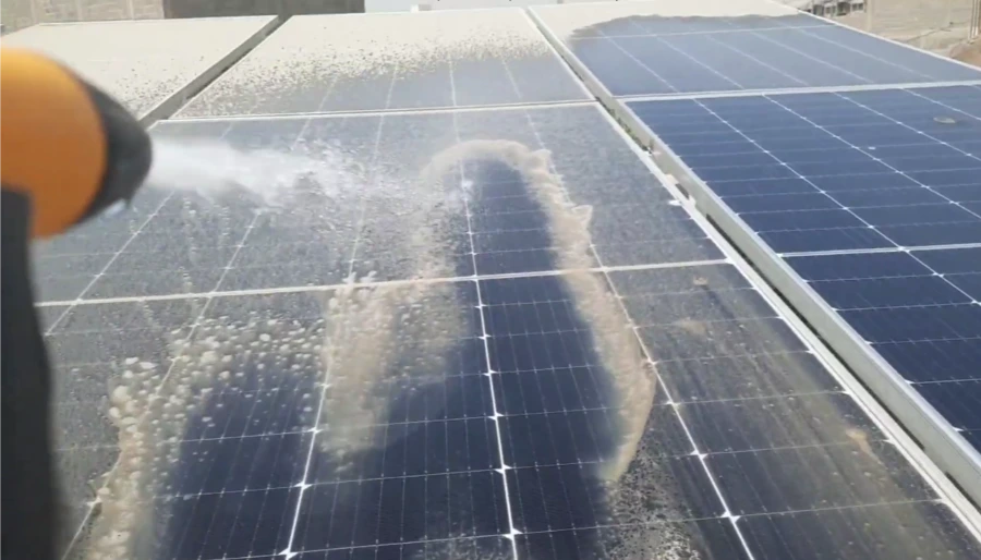 Garden hose spraying dusty solar panels, turning the dust into muddy runoff