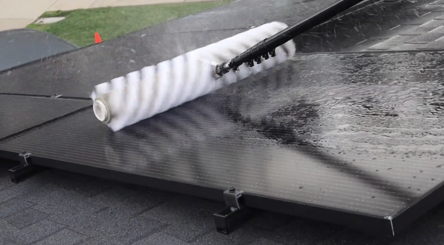 Soft rotating brush cleaning black solar panels on a low-slope roof, solar panel cleaning Paradise NV